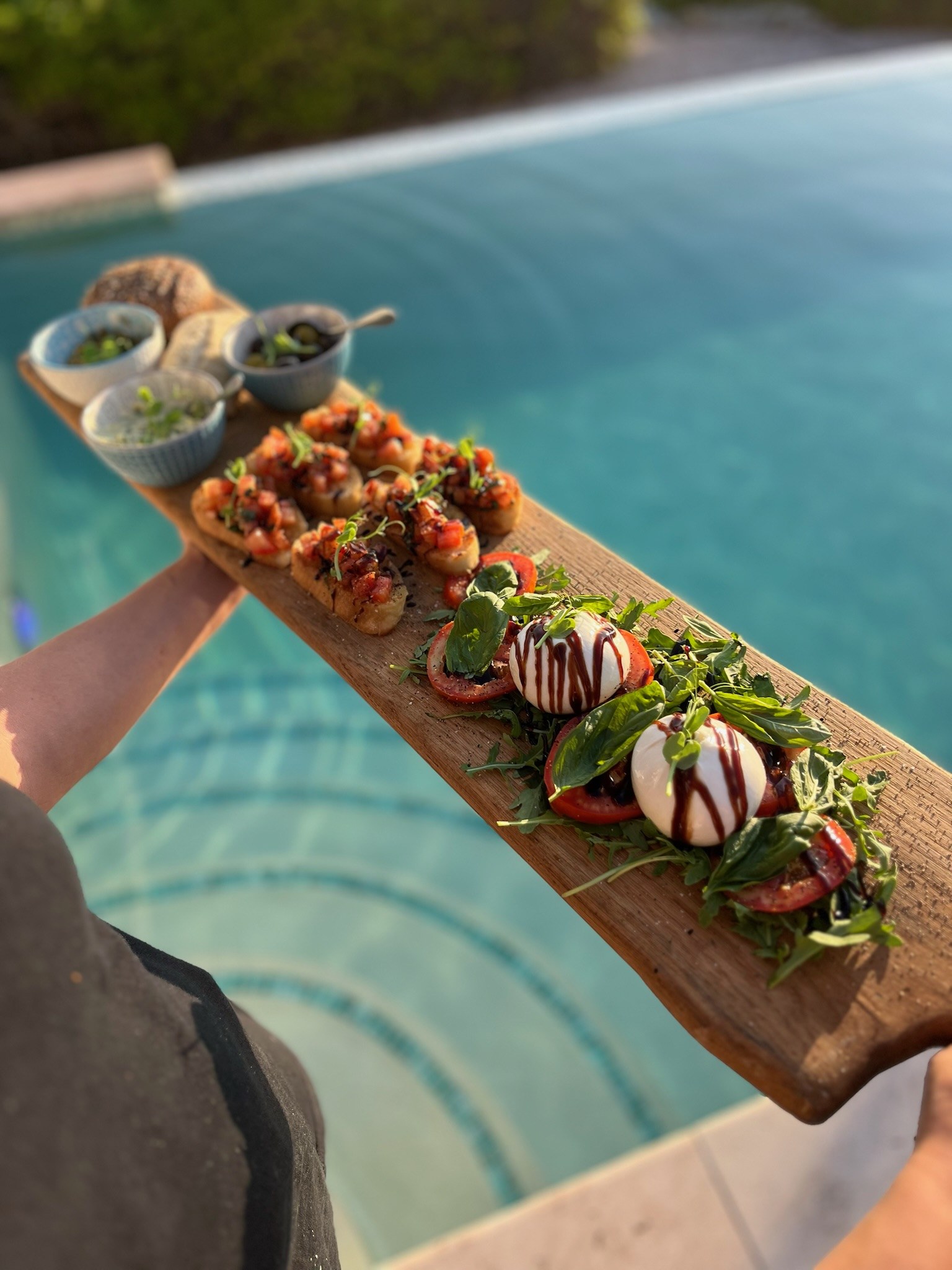 BBQ Queen appetizers served on a wooden board beside the pool